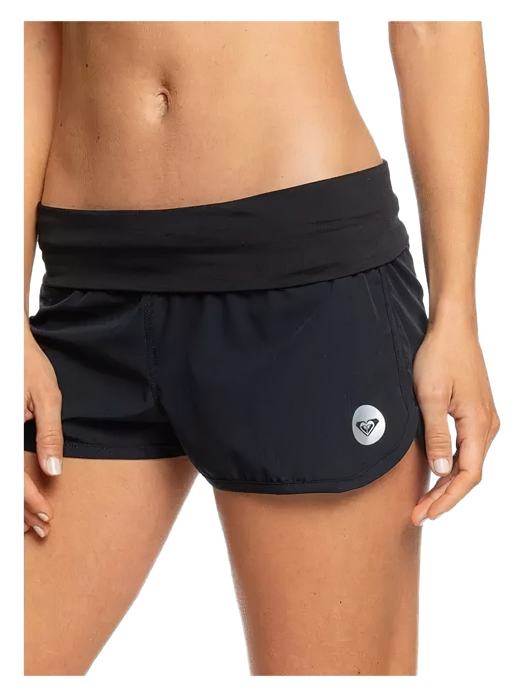 Mujer vistiendo pantalones cortos deportivos de color negro marca Roxy con logotipo circular plateado.