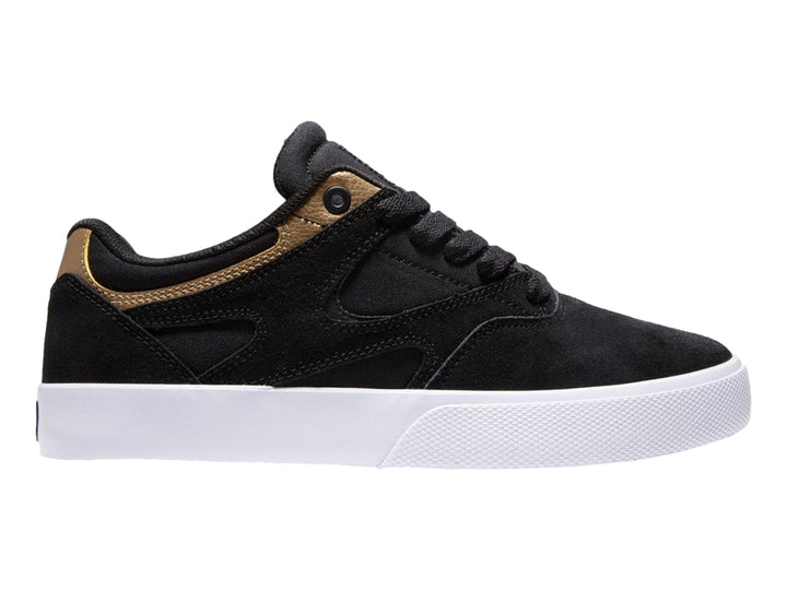 Tenis DC Shoes modelo Kalis Vulc en color negro con detalles dorados y suela blanca.