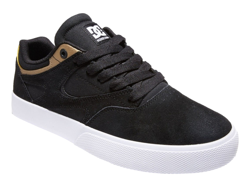Tenis DC Shoes modelo Kalis Vulc en color negro con detalles dorados y suela blanca.