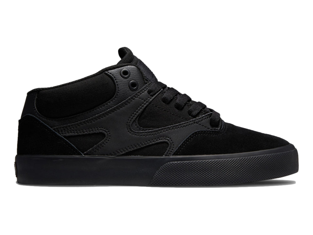 Tenis DC Shoes Kalis Vulc Mid en color negro total, diseño de corte medio y suela vulcanizada.