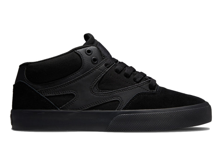 Tenis DC Shoes Kalis Vulc Mid en color negro total, diseño de corte medio y suela vulcanizada.