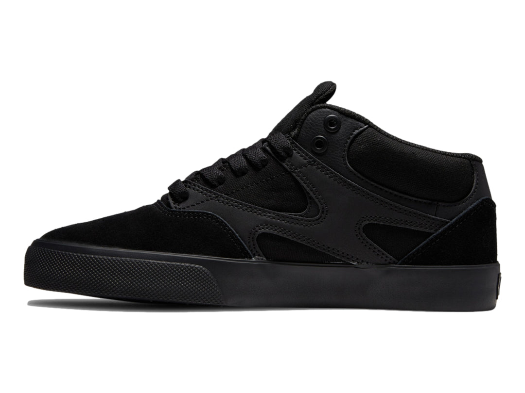 Tenis DC Shoes Kalis Vulc Mid en color negro total, diseño de corte medio y suela vulcanizada.