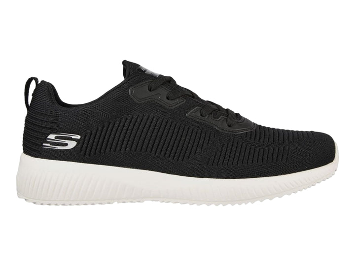 Tenis deportivos Skechers color negro con suela blanca y tejido acanalado.