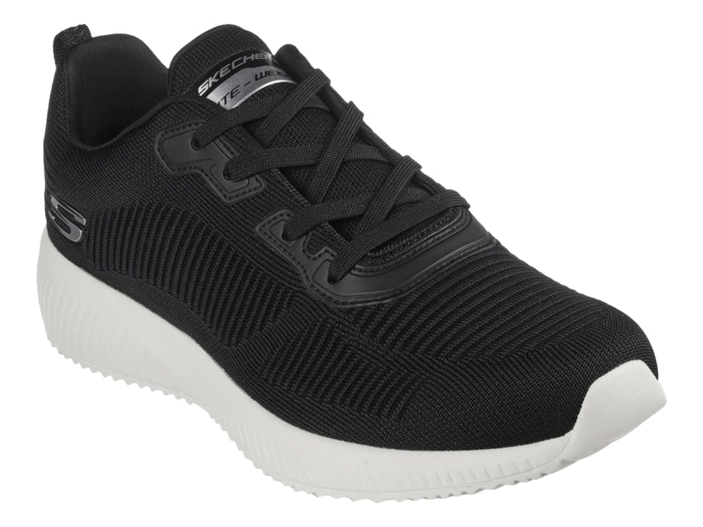 Tenis deportivos Skechers color negro con suela blanca y tejido acanalado.