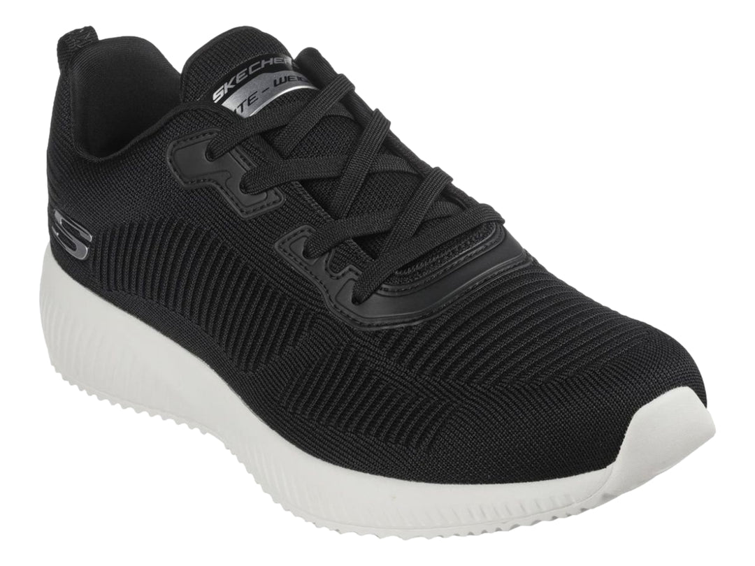 Tenis deportivos Skechers color negro con suela blanca y tejido acanalado.