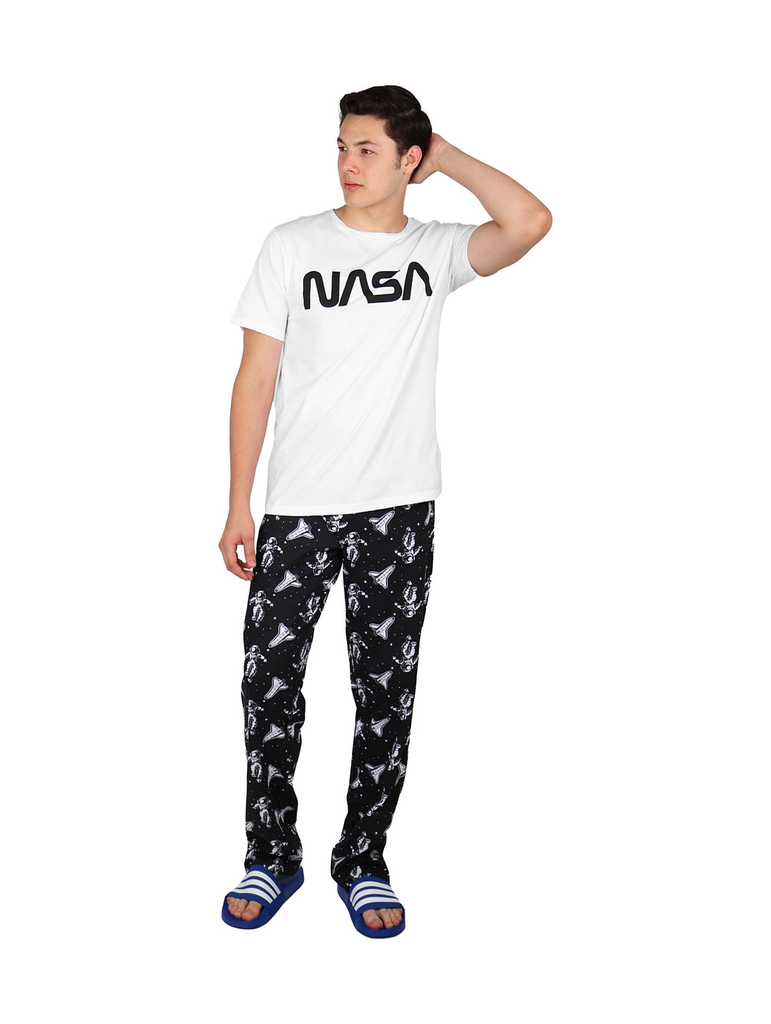 Hombre vistiendo pantalón largo negro con estampado blanco y camiseta blanca.