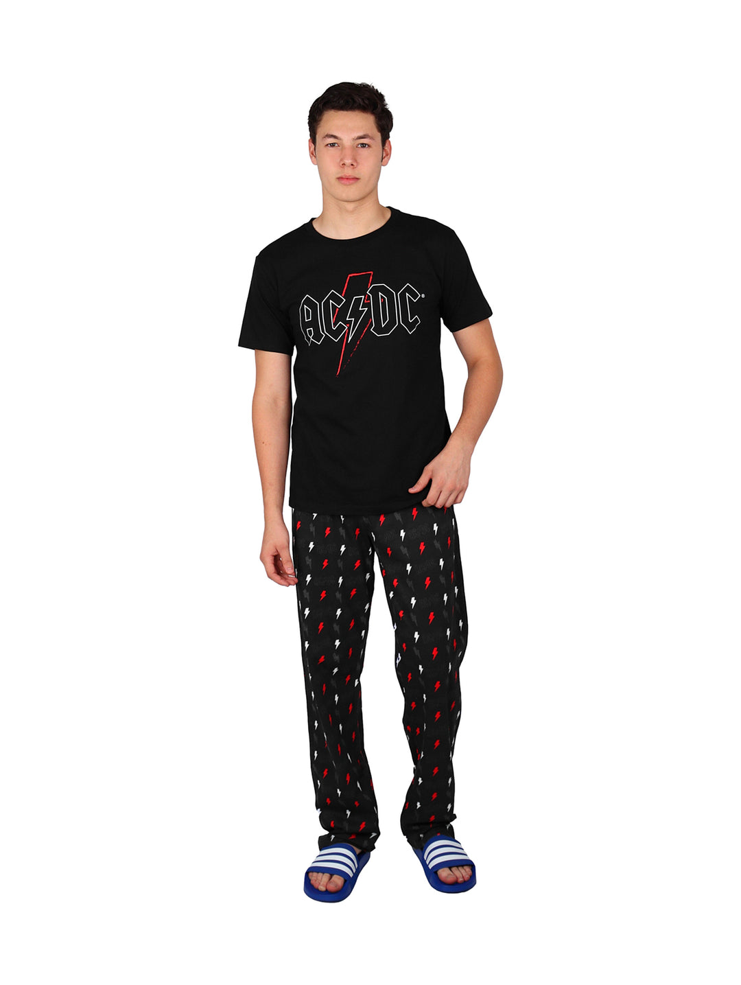 Hombre vistiendo pijama de pantalón largo negro con estampado de rayos rojos y camiseta negra.