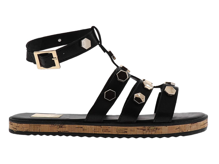 Sandalia casual negra con detalles hexagonales dorados y suela de corcho.