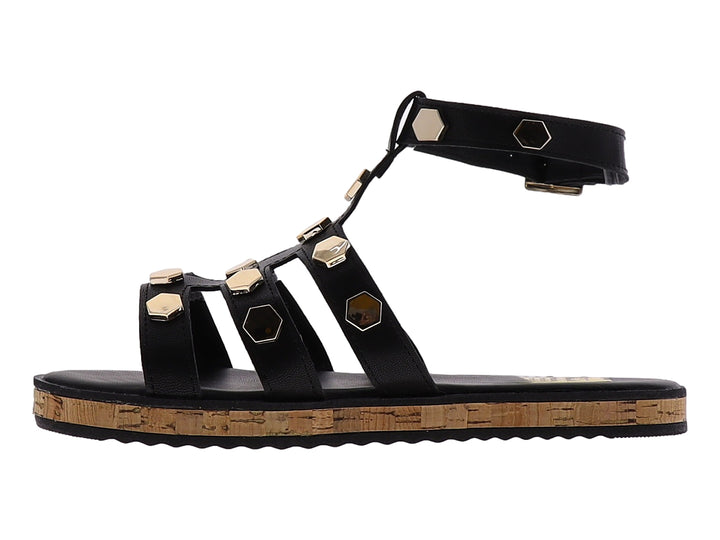 Sandalia casual negra con detalles hexagonales dorados y suela de corcho.
