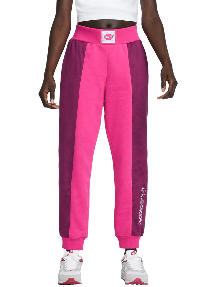 Pantalones deportivos Nike en colores rosa y morado con diseño de bloques laterales y cintura elástica.