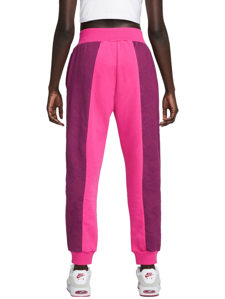 Pantalones deportivos Nike en colores rosa y morado con diseño de bloques laterales y cintura elástica.
