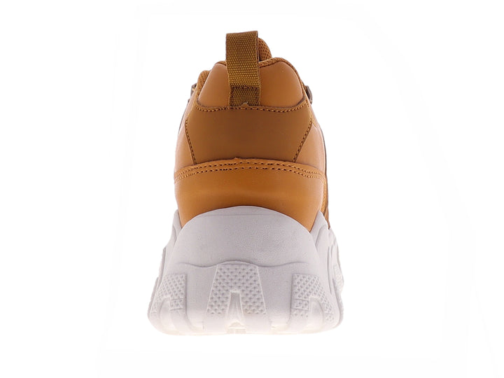 Tenis deportivos color mostaza con suela blanca gruesa y diseño ondulado.