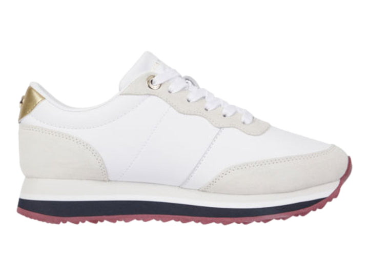 Tenis Tommy Hilfiger color blanco con detalles en beige, suela azul y guinda, y acento dorado en el talón.