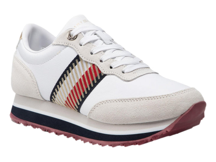 Tenis Tommy Hilfiger color blanco con detalles en beige, suela azul y guinda, y acento dorado en el talón.