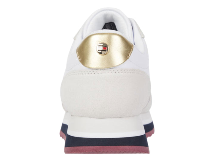 Tenis Tommy Hilfiger color blanco con detalles en beige, suela azul y guinda, y acento dorado en el talón.