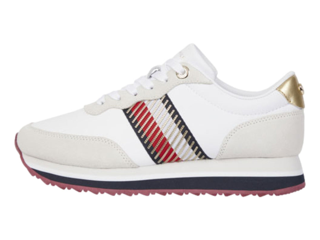 Tenis Tommy Hilfiger color blanco con detalles en beige, suela azul y guinda, y acento dorado en el talón.