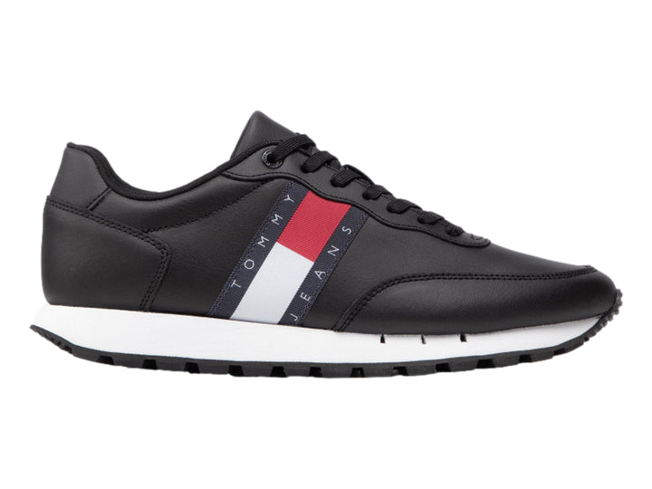 Tenis Tommy Hilfiger de cuero negro con banda tricolor en el costado y suela blanca.