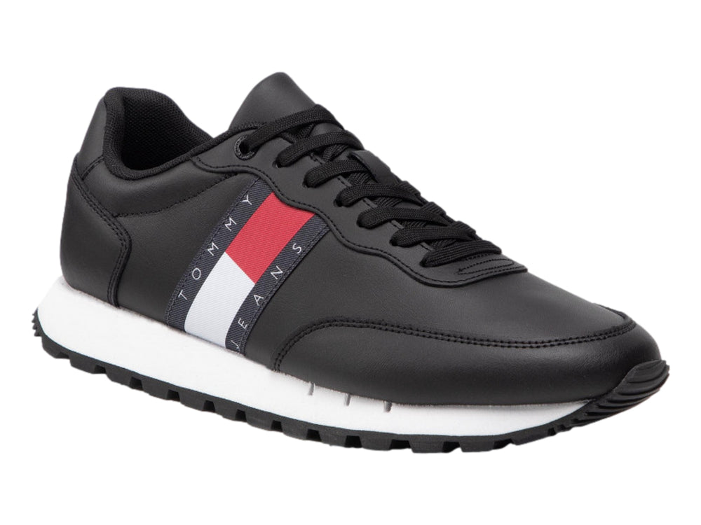 Tenis Tommy Hilfiger de cuero negro con banda tricolor en el costado y suela blanca.