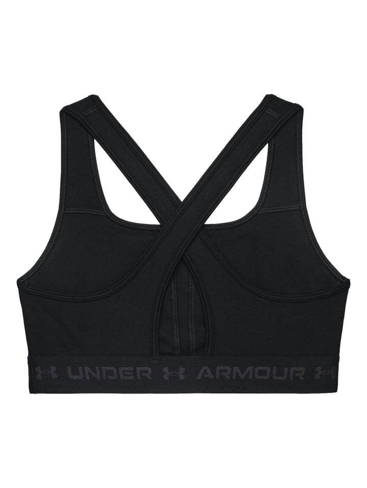 Mujer vistiendo un top deportivo Under Armour color negro con banda elástica gris en la base.