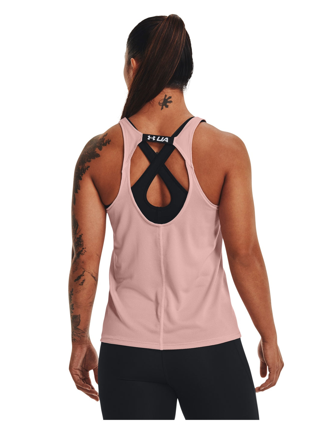 Mujer vistiendo una camiseta deportiva sin mangas Under Armour en color rosa retro.