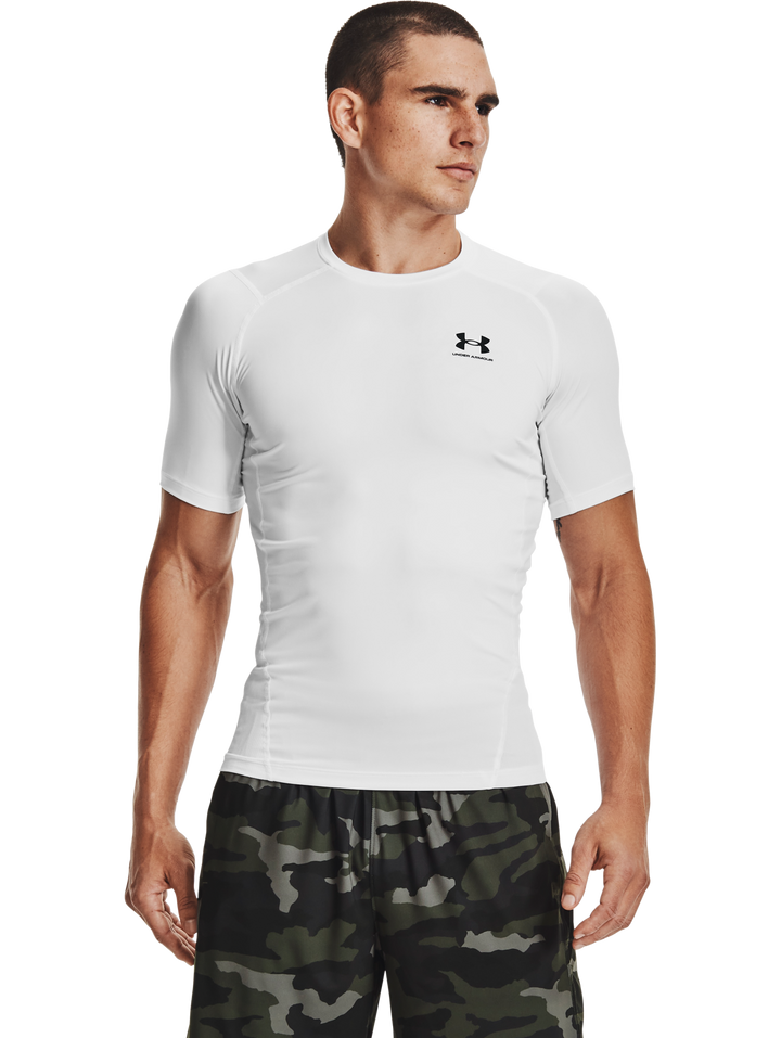 Hombre vistiendo camiseta deportiva de compresión Under Armour color blanco con logo negro en el pecho.