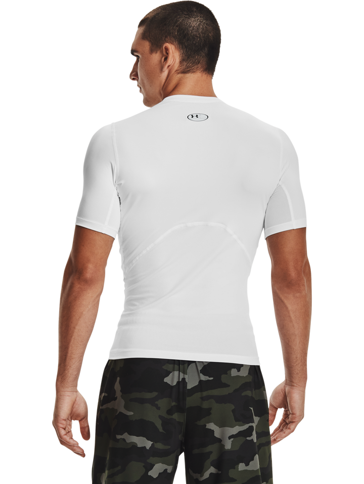 Hombre vistiendo camiseta deportiva de compresión Under Armour color blanco con logo negro en el pecho.