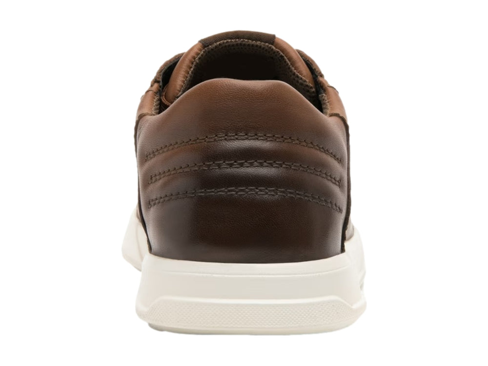 Tenis casuales de cuero color marrón con suela blanca y agujetas a juego.
