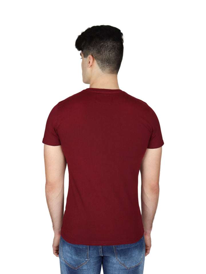 Hombre vistiendo playera de manga corta color tinto con pequeño logo blanco en el pecho.