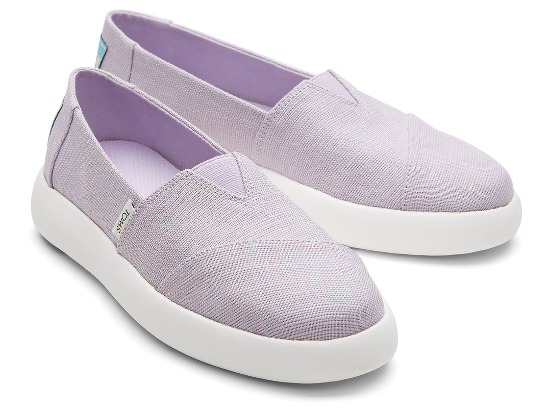 Zapatos slip-on TOMS de color lila con suela blanca.