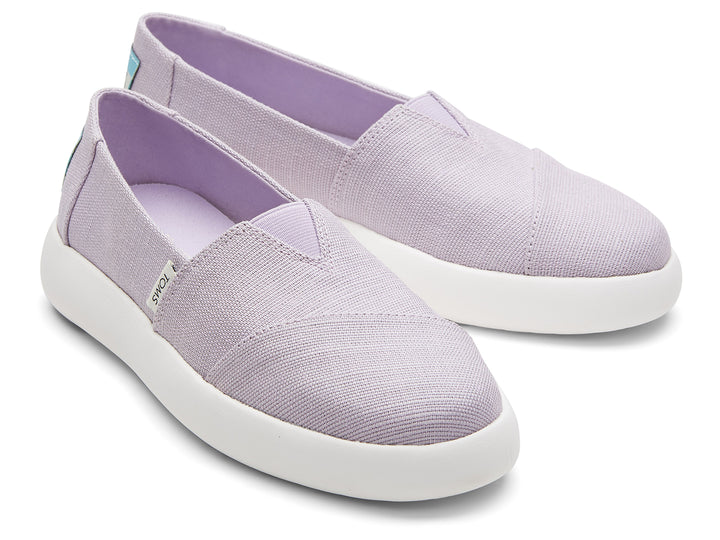 Zapatos slip-on TOMS de color lila con suela blanca.