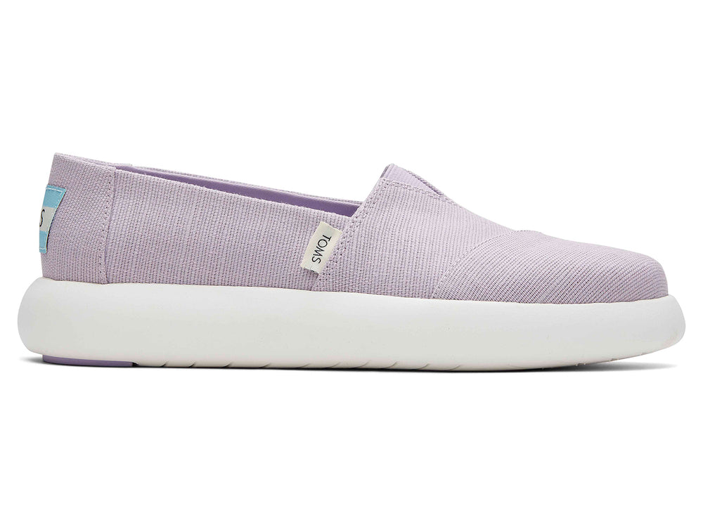 Zapatos slip-on TOMS de color lila con suela blanca.