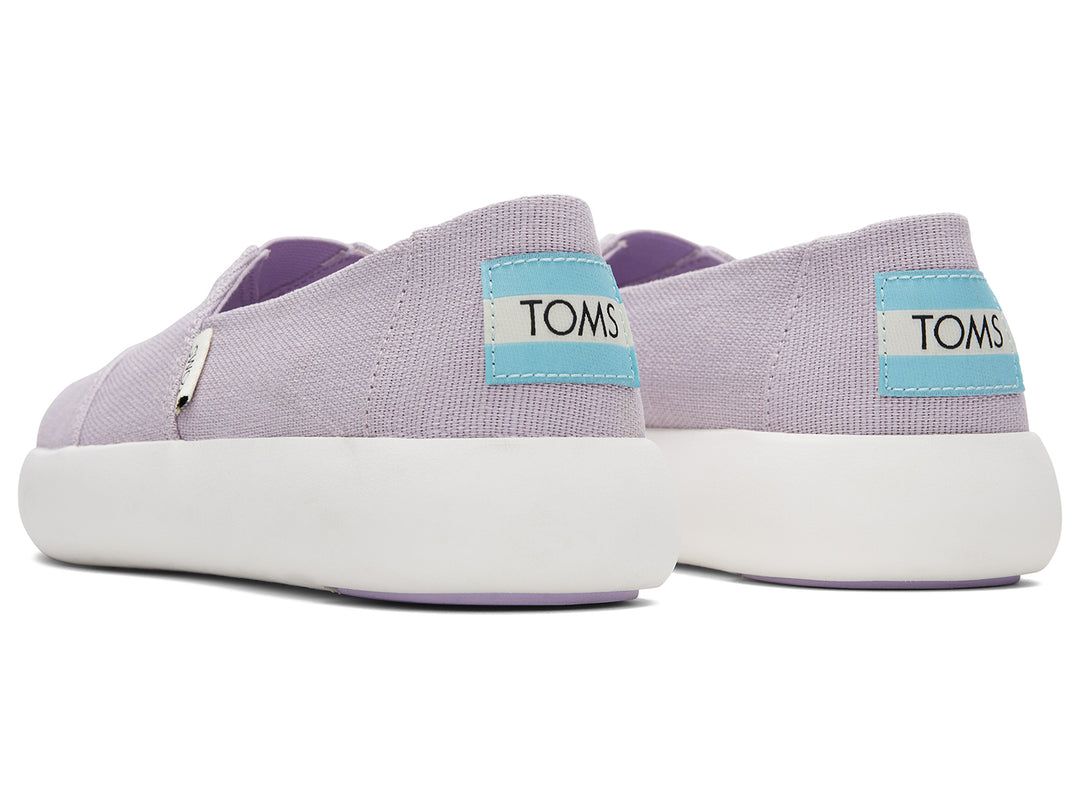Zapatos slip-on TOMS de color lila con suela blanca.