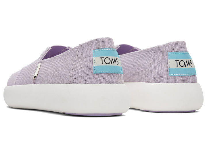 Zapatos slip-on TOMS de color lila con suela blanca.