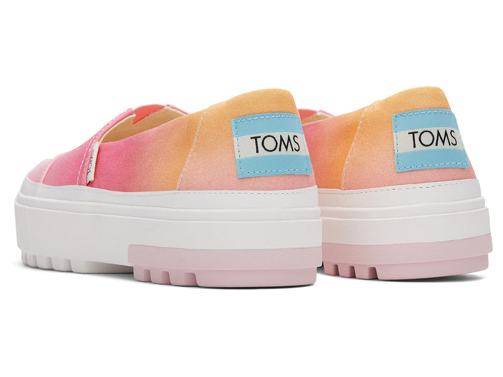 Zapato TOMS estilo slip-on con plataforma blanca y diseño en degradado de colores naranja a rosa.