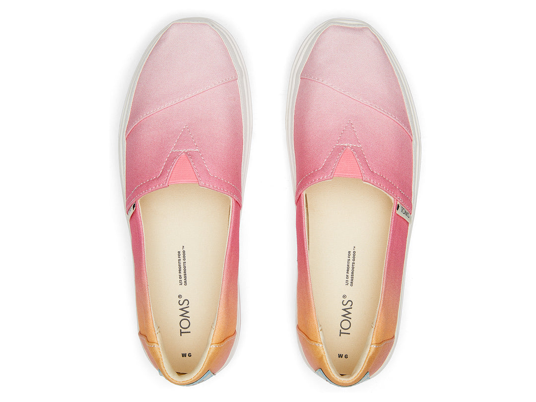 Zapato TOMS estilo slip-on con plataforma blanca y diseño en degradado de colores naranja a rosa.