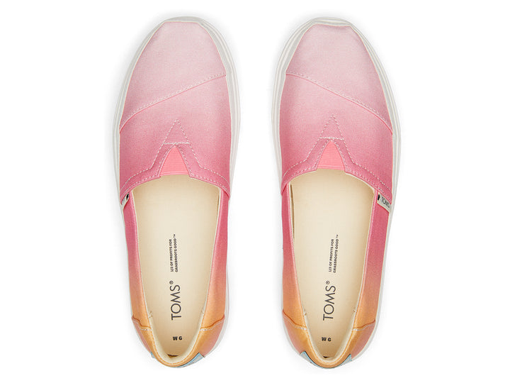 Zapato TOMS estilo slip-on con plataforma blanca y diseño en degradado de colores naranja a rosa.