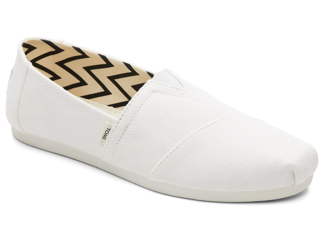 Zapato estilo alpargata TOMS de color blanco en tela reciclada con interior estampado en zigzag negro y beige.
