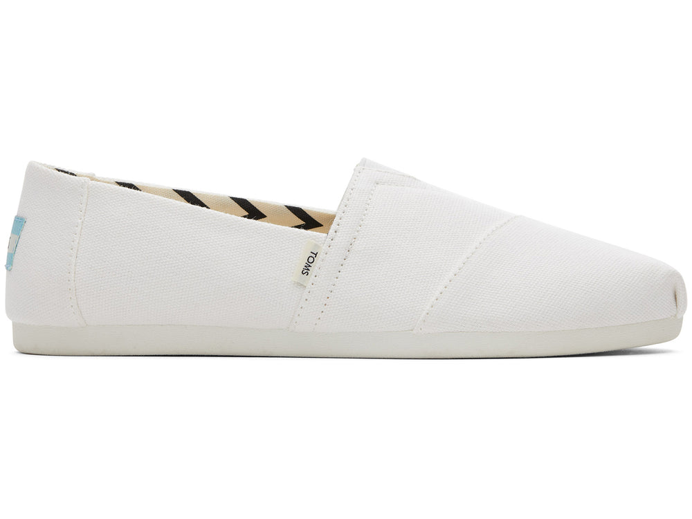 Zapato estilo alpargata TOMS de color blanco en tela reciclada con interior estampado en zigzag negro y beige.
