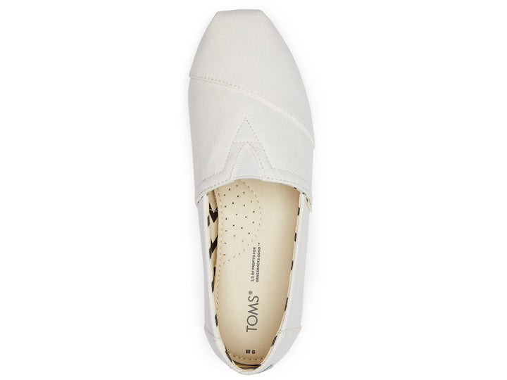 Zapato estilo alpargata TOMS de color blanco en tela reciclada con interior estampado en zigzag negro y beige.