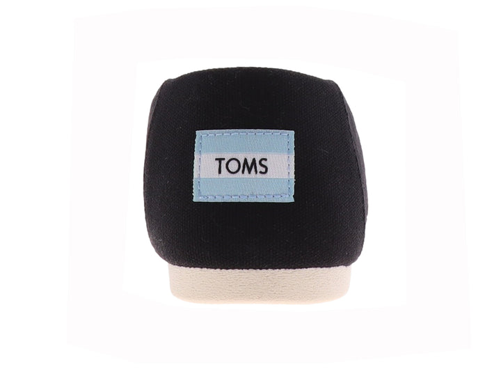 Zapato plano slip-on TOMS de tela negra con suela blanca.