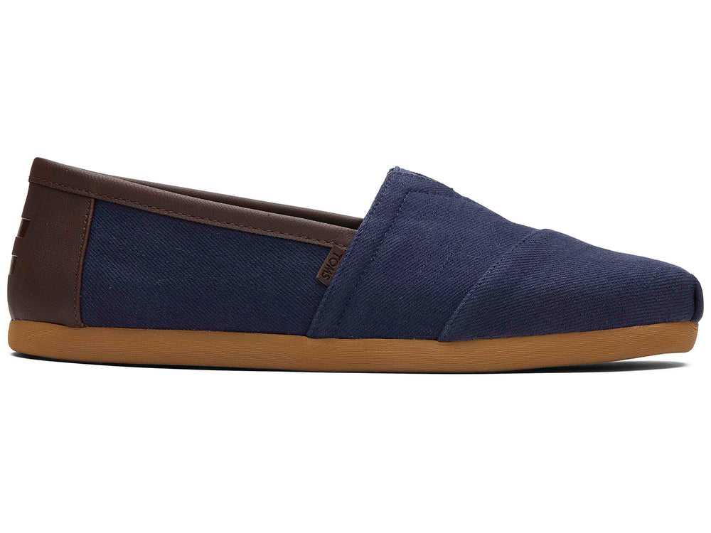 Par de zapatos planos estilo slip-on en color azul marino con suela color café.