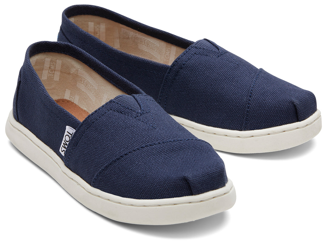 Zapatos slip-on TOMS color azul marino con suela blanca para niños.