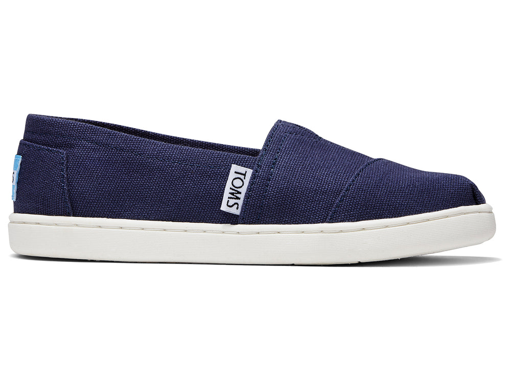 Zapatos slip-on TOMS color azul marino con suela blanca para niños.