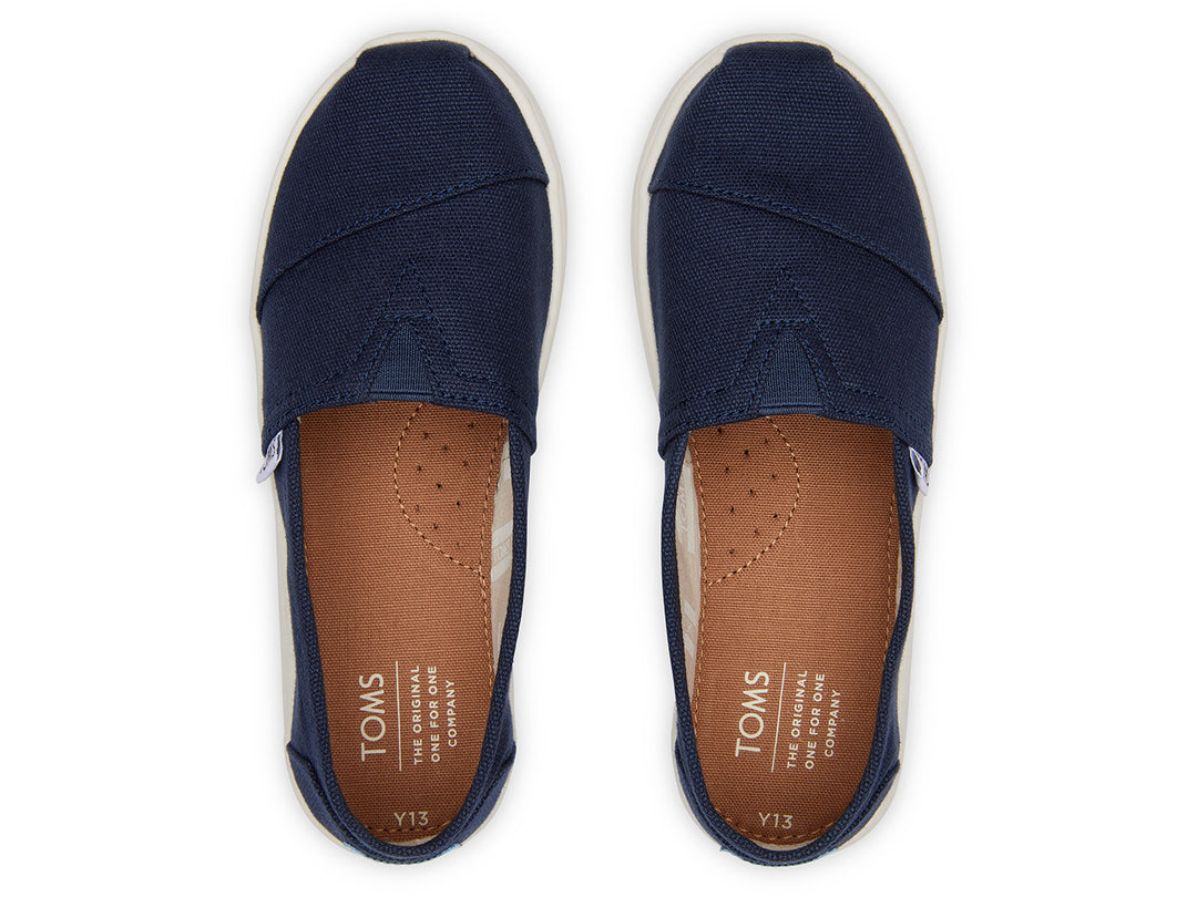 Zapatos slip-on TOMS color azul marino con suela blanca para niños.