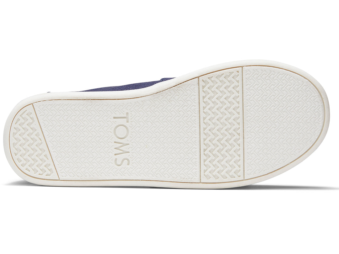 Zapatos slip-on TOMS color azul marino con suela blanca para niños.