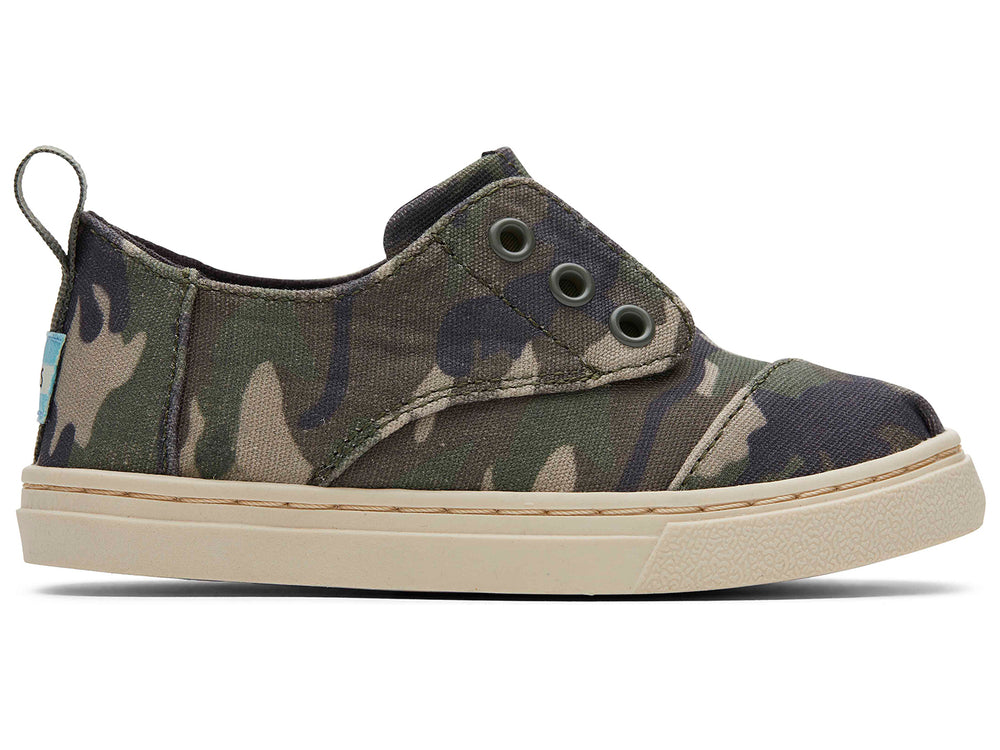 Par de zapatos infantiles TOMS con estampado de camuflaje en tonos verdes y beige, suela clara y diseño casual.