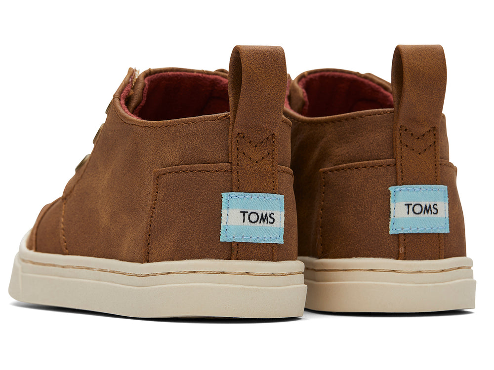 Zapato casual infantil TOMS color café toffee con suela blanca y diseño sin cordones.