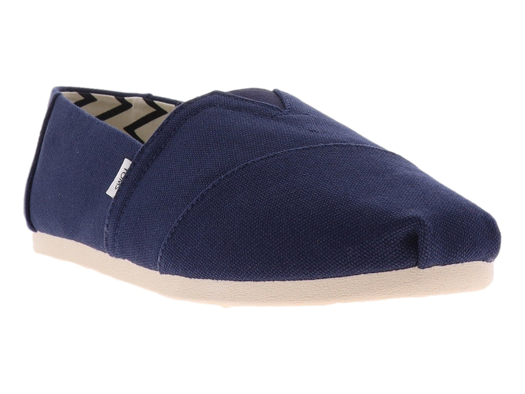 Zapato plano slip-on TOMS en color azul marino con suela beige y forro interior a rayas.