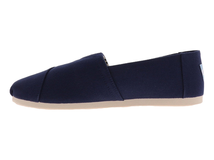 Zapato plano slip-on TOMS en color azul marino con suela beige y forro interior a rayas.