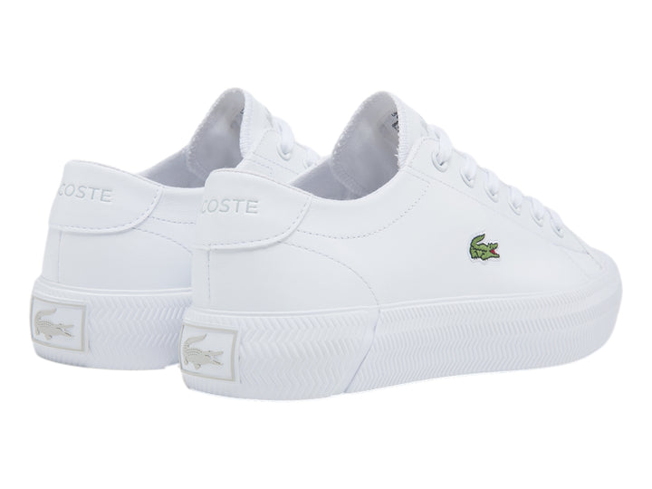 Tenis blancos Lacoste con logotipo de cocodrilo verde y suela blanca.